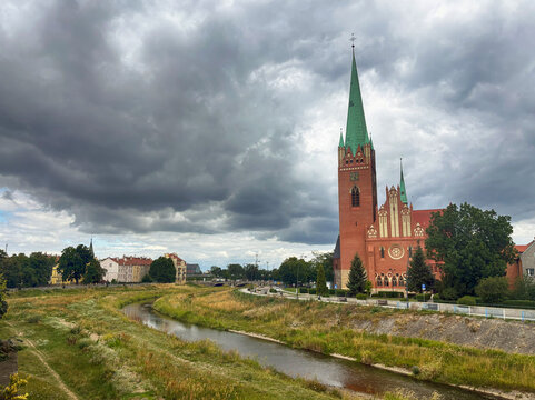 View from a bridge over the Kaczawa River of the Church of St Hyacinth on an overcast day in summer, Legnica, Poland