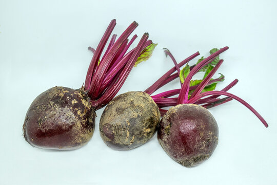 Close-up of three beetroot in a row on a white background