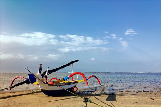 Close-up of a Traditional wooden outrigger boat (jukung) on a sandy beach, Bali, Indonesia