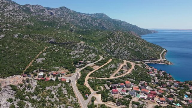 Aerial view of winding road through mountains along the sea