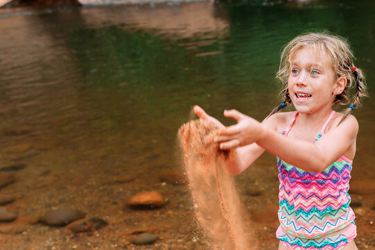 Child Playing in Sand on Beach