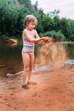 Little Girl Throwing Sand on Beach