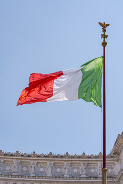 Italian flag on a flagpole in front of the Monument to Victor Emmanuel II, Rome, Lazio, italy