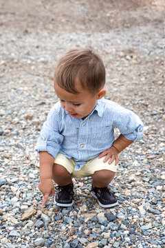 Young boy crouching on a footpath pointing at a stone, Albion Basin Meadow, Albion Basin, Little Cottonwood Canyon, Utah, USA