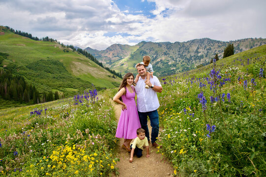 Family portrait of a couple with their two young sons standing on a footpath in an alpine landscape, Albion Basin Meadow, Albion Basin, Little Cottonwood Canyon, Utah, USA