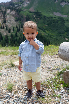 Close-up of a young boy with his finger in his mouth standing in an alpine landscape, Albion Basin Meadow, Albion Basin, Little Cottonwood Canyon, Utah, USA