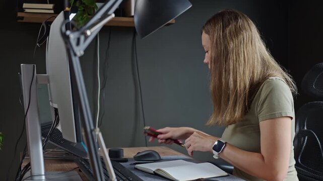 Woman organizing stationery on desk in home office