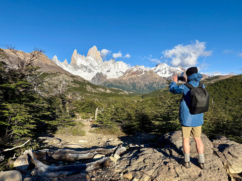 Rear view of a Man taking a photo of Mt Fitz Roy (Cerro Chalten) in the Andes, Los Glaciares National Park, Patagonia, Santa Cruz, Argentina