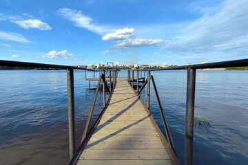 Fototapeta premium Empty wooden pier with a sky and calm water