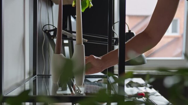Woman placing decor on glass shelf at home