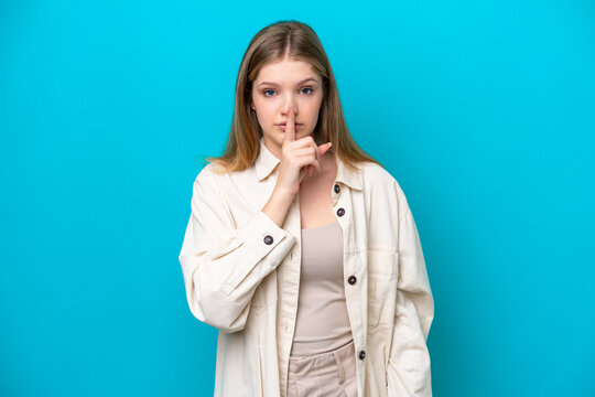 Teenager Russian girl isolated on blue background showing a sign of silence gesture putting finger in mouth