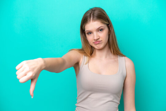 Teenager Russian girl isolated on blue background showing thumb down with negative expression