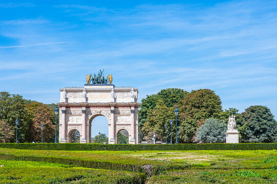 Visitors gather near the Axe Historique (historical axis) in Paris, France, during summer with clear skies and green gardens all around