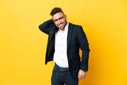 Businessman over isolated yellow background laughing