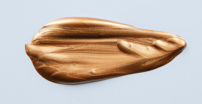 Golden liquid brushstroke creating shimmering metallic texture