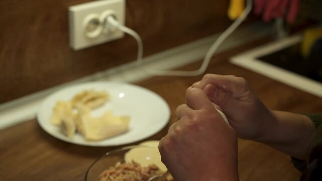 Woman making dumplings in kitchen at home