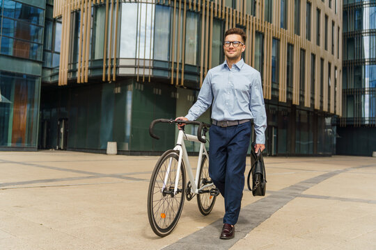 Modern professional navigating a vibrant urban landscape while walking alongside a sleek bicycle