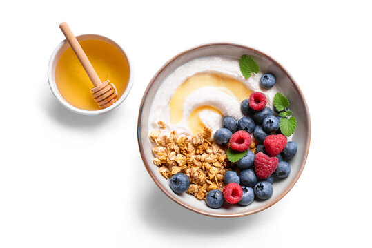 Granola bowl with greek yogurt, berries and honey for healthy breakfast.