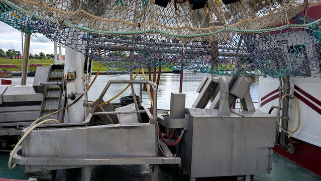 Shrimp trawler deck with fishing nets and processing equipment. 