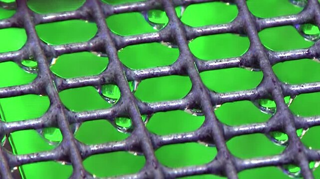 Tiny crystalline water droplets adhere to the intricate dark mesh of an active hydro air filter.