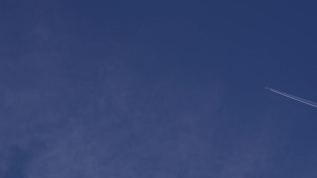 異なる高度を飛ぶ2機の飛行機と1機から白く伸びる飛行機雲