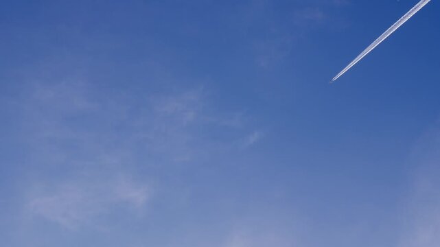 異なる高度を飛ぶ2機の飛行機と1機から白く伸びる飛行機雲