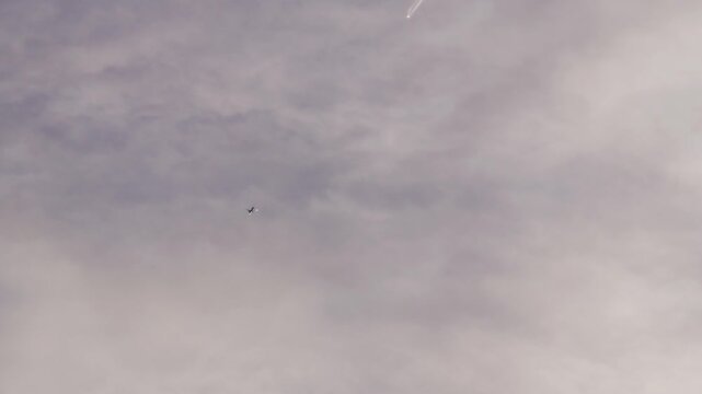 異なる高度を飛ぶ2機の飛行機と1機から白く伸びる飛行機雲