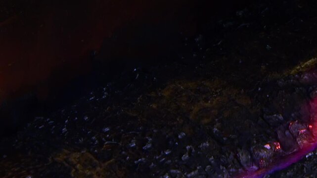 A vibrant, crimson fluid gracefully flows across the intricate surface of an advanced air filter.