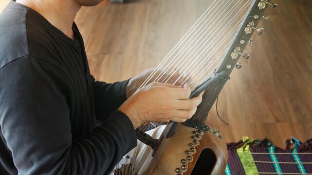 Musician hands playing the harp lyre ethnic musical string instrument