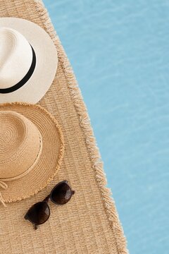Sun hats and sunglasses on a woven mat