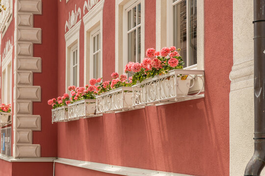 Ortisei, Urtij&euml;i, St. Ulrich, Italy. Red Alpine facade with ornate windows and pink flowers in Val Gardena