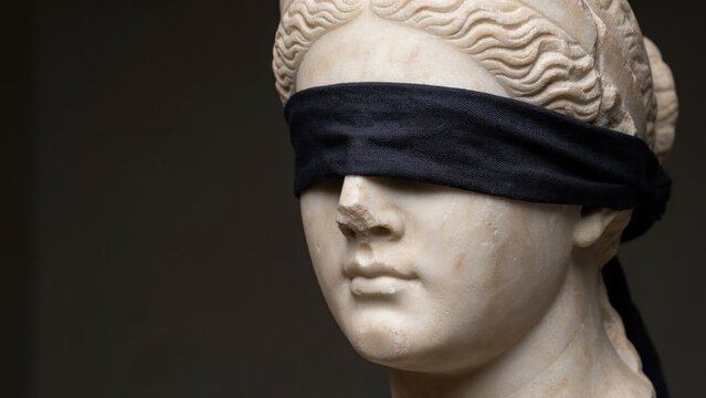 Blindfolded Lady Justice marble statue, classical Greek goddess sculpture with black blindfold, justice and law concept