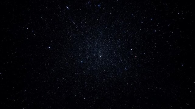 Glowing cosmic star field expands through deep black space with countless tiny light points drifting outward creating abstract universe background with subtle blue illumination and atmospheric depth