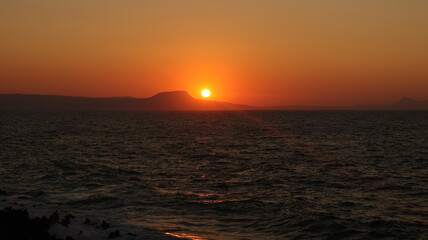 Fototapeta premium A beautiful sunset view above the sea and akrotiri, from the port of Rethymno, Crete, Greece