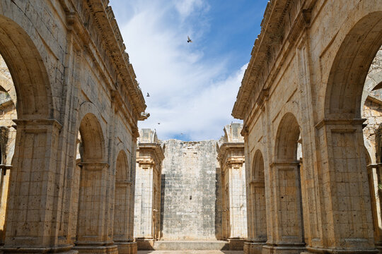 Unfinished church ruins with stone arches and blue sky