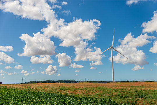 &Eacute;olienne moderne dans un vaste champ agricole sous un ciel bleu nuageux