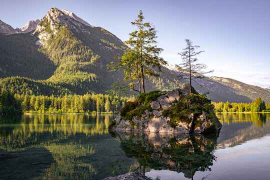 Felsinsel im Hintersee mit Bergluft-Spiegelung und Reiteralpe im Sonnenlicht.