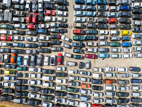 Aerial view of stacked cars and auto parts at an outdoor junkyard