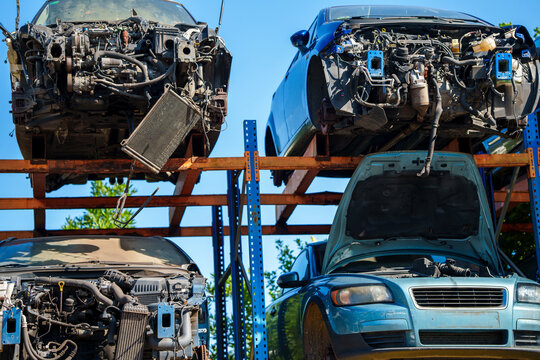 Stacked cars for used auto parts sale at an outdoor junkyard