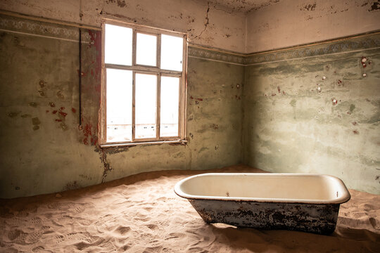 Kolmanskop ghost town bathtub filling with desert sand