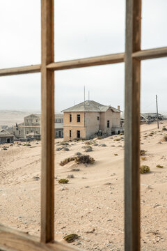 vertical Kolmanskop ghost town desert landscape through window frame