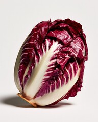 Fototapeta premium A single head of fresh radicchio lettuce with deep purple and white leaves isolated on a clean white background, with a soft, drop shadow below