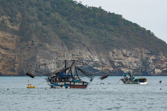 Puerto Lopez, Fishing boats in the cloudy morning along a rocky shore in a port of Puerto Lopez, Manabi province, Ecuador