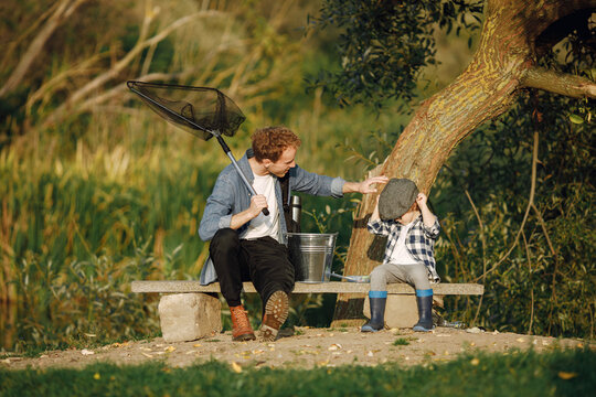 Young father teaching his little toddler son how to fish