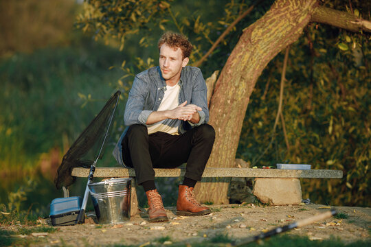 Young man sitting on a bench and fishing