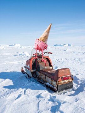 Strawberry Ice Cream Cone Melting on Vintage Snowmobile in Tundra