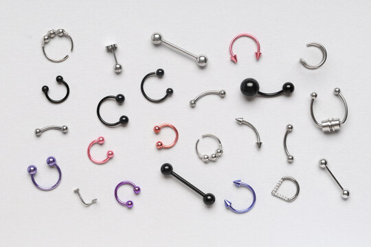 Body piercing jewelry collection, fashion and self-expression, various types of rings and barbells on a white background