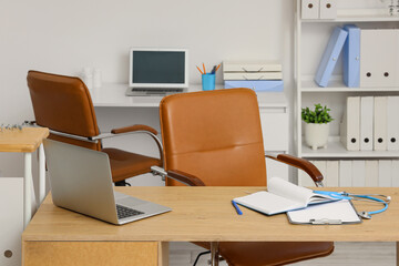 Fototapeta premium Doctors workplace with laptop and clipboards in medical office