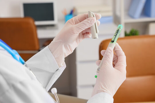 Female doctor with hormone injection in clinic, closeup
