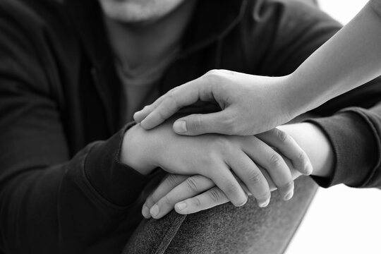 Female psychologists hand supporting man with suicidal thoughts in office, closeup